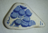 Hliněný střep, s modrou malbou, možná hroznové víno