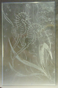 Sklo s vybroušeným obrazem dvou mořských koníků